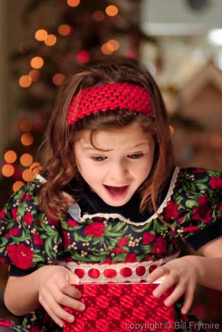 young girl opening Christmas present