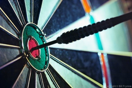 close up photo of a dart board with a dart on thebullseye