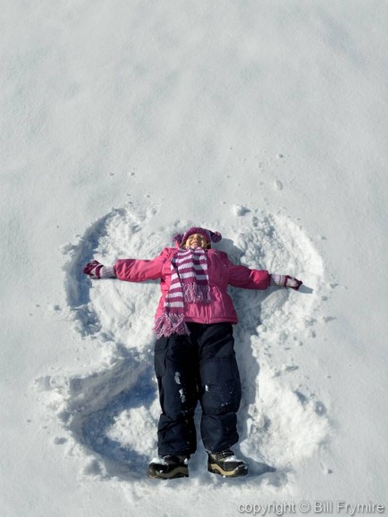 young girl making a snow angel