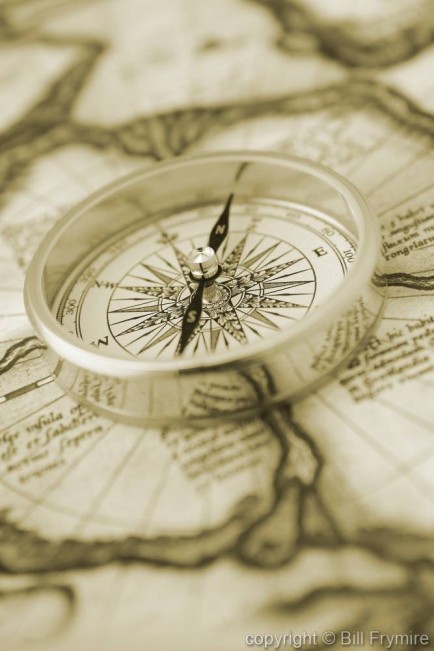 Metal compass on antique map