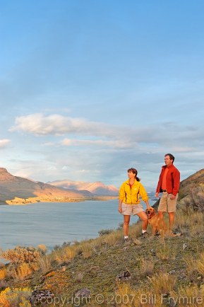 couple walking dog by lake