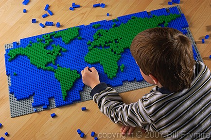 a boy builds a world map with blocks
