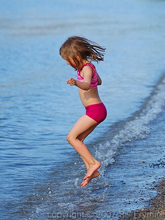 young girl jumping waves 