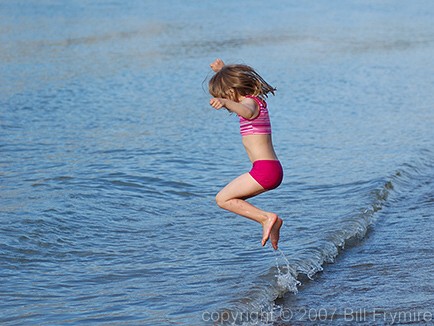young girl jumping waves
