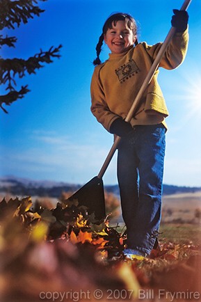 young girl raking leaves