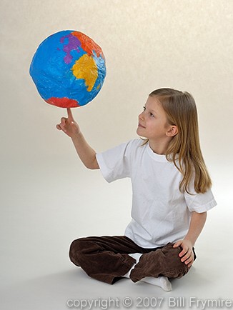 young girl spinning globe on finger