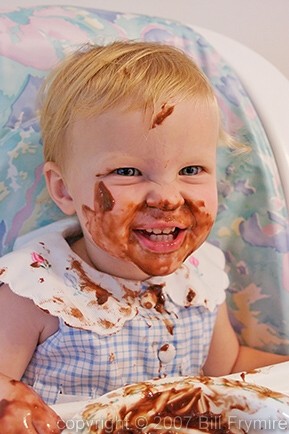 baby girl eating chocolate pudding