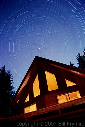 cabin at night with star trails