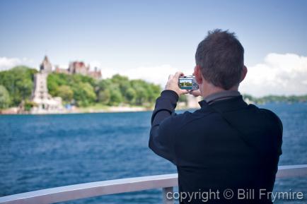 Man taking photo of Boldt Castle in the Thousand Islands, USA - model released