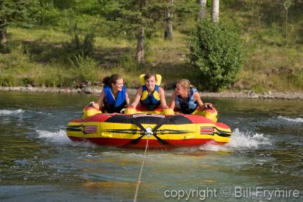 three girls tubing on a lake