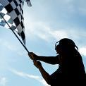 man in silhouette waving checkered flag