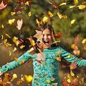 girl playing in leaves