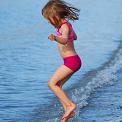 young girl jumping waves 