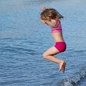 young girl jumping waves