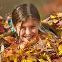 girl playing in a pile of leaves