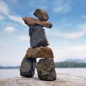 Inukshuk sitting on a rock by the ocean