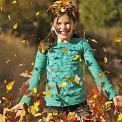 girl playing in leaves
