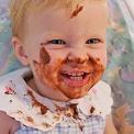 baby girl eating chocolate pudding