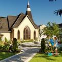 artist painting in a garden by a church