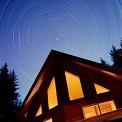 cabin at night with star trails