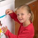 girl putting drawing on fridge door